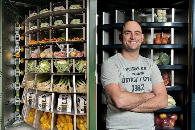 Vendingmachine van Vendavid met groenten en fruit in draaiende vakken, naast een man met gekruiste armen voor een open automaat