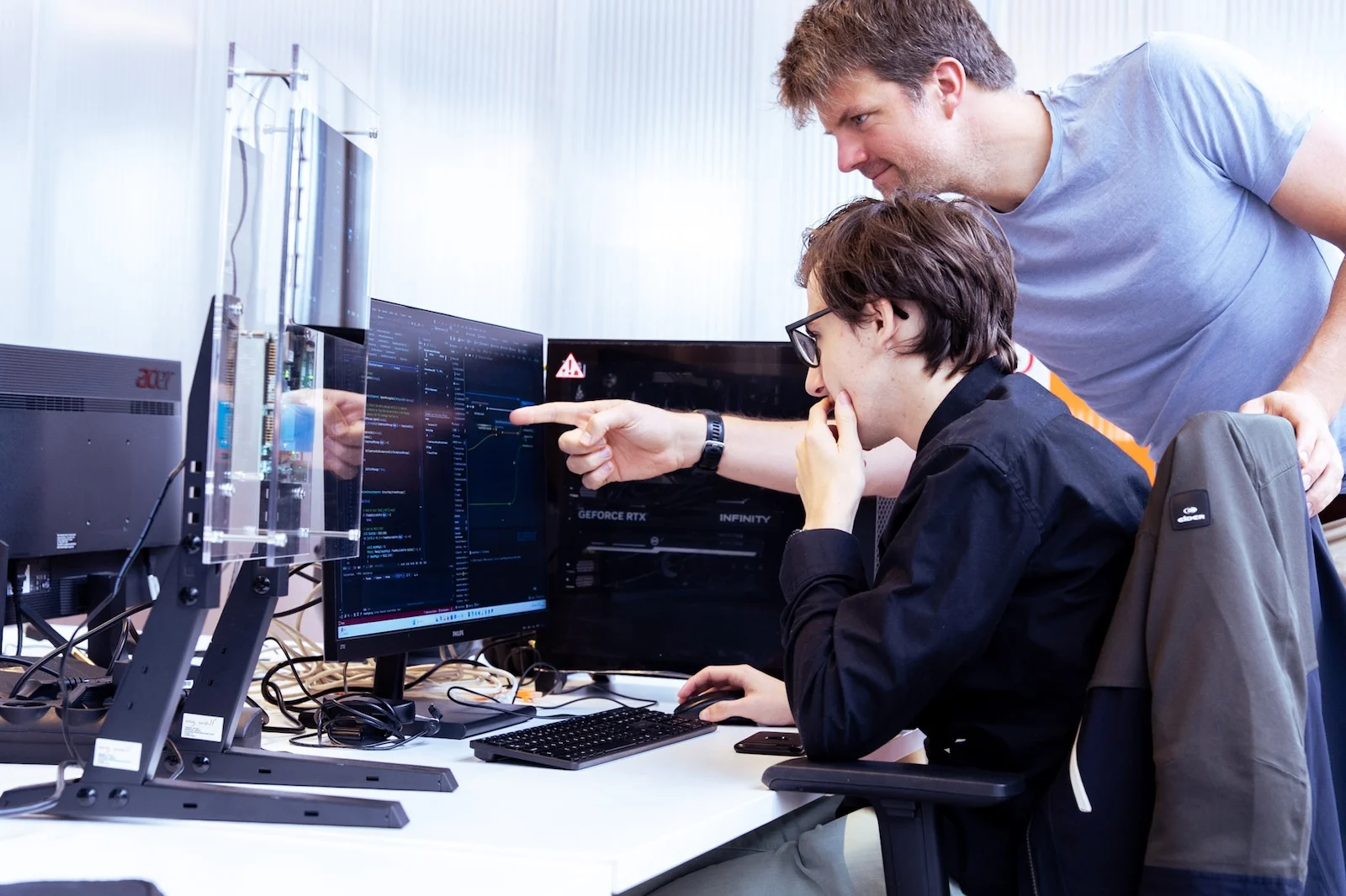 Twee engineers van Invisto bespreken code op een scherm naast een testopstelling
